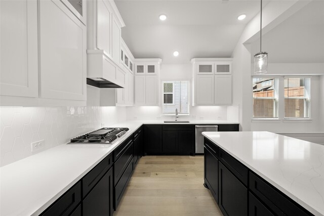 kitchen featuring white cabinetry, sink, stainless steel appliances, light hardwood / wood-style flooring, and decorative light fixtures