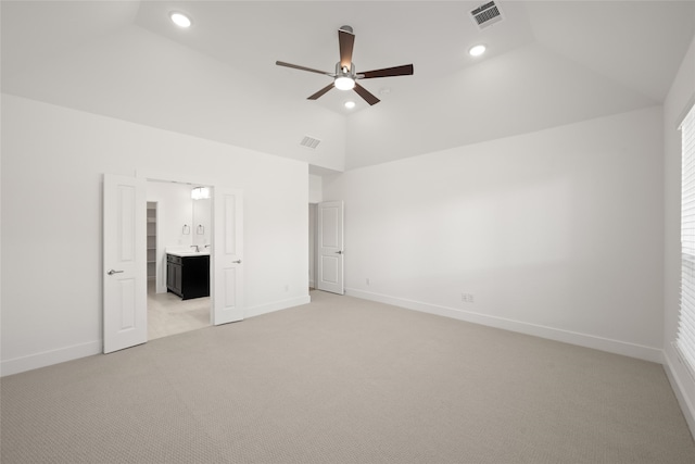 unfurnished bedroom with high vaulted ceiling, sink, ensuite bath, ceiling fan, and light colored carpet