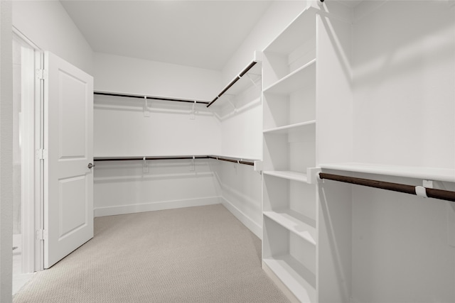 walk in closet featuring light carpet