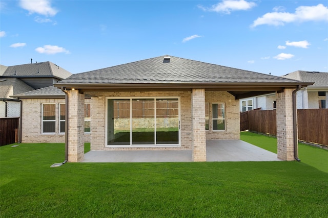 back of property featuring a lawn and a patio