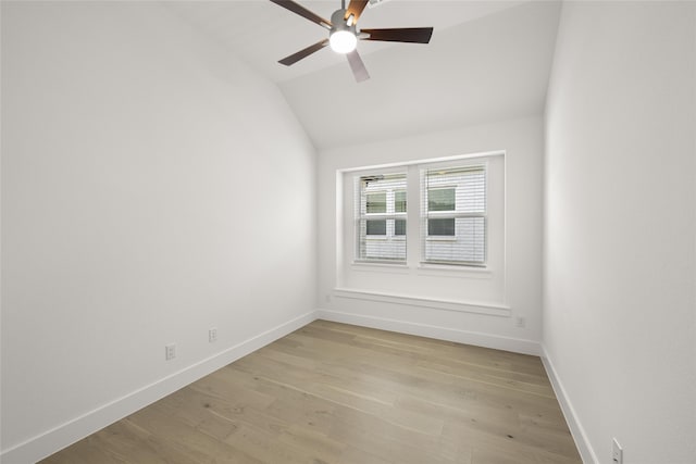 spare room featuring light hardwood / wood-style flooring, vaulted ceiling, and ceiling fan