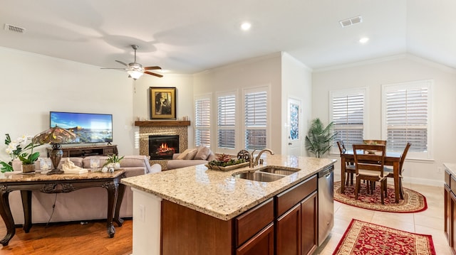 kitchen with ceiling fan, a kitchen island with sink, sink, and a healthy amount of sunlight