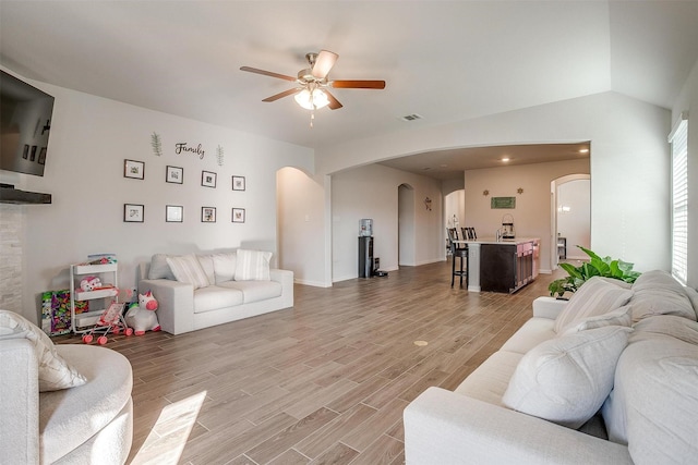 living room featuring ceiling fan and lofted ceiling