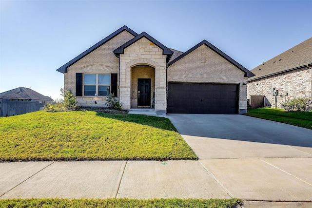 french provincial home featuring a front yard and a garage