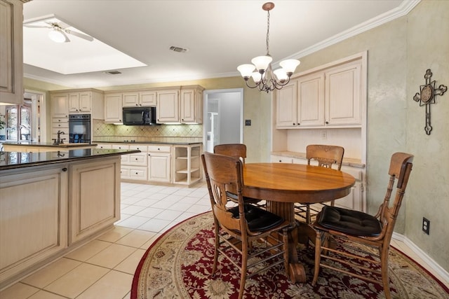 tiled dining space featuring sink, ceiling fan with notable chandelier, and ornamental molding