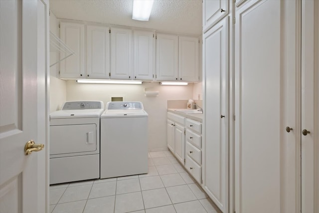 laundry room featuring independent washer and dryer, light tile patterned floors, a textured ceiling, cabinets, and sink