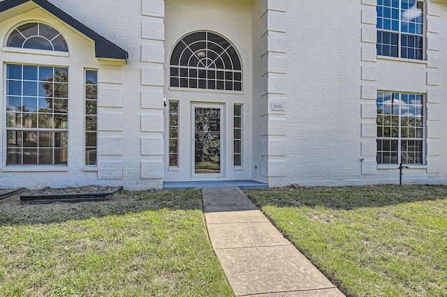 doorway to property featuring a lawn