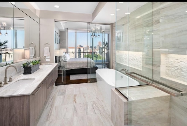 bathroom featuring a notable chandelier, vanity, and separate shower and tub