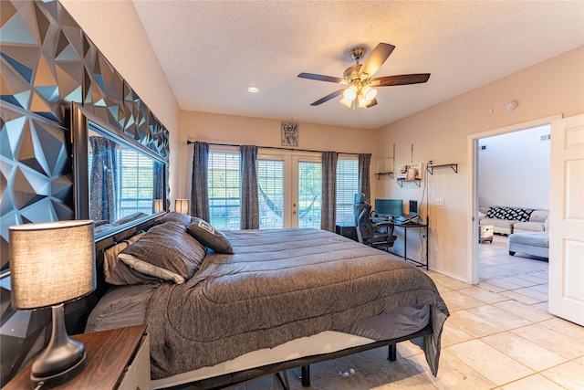 tiled bedroom with ceiling fan and a textured ceiling