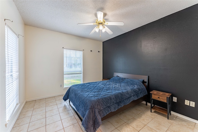 tiled bedroom featuring a textured ceiling and ceiling fan