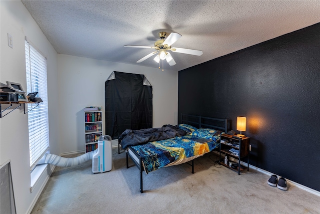 carpeted bedroom with ceiling fan and a textured ceiling