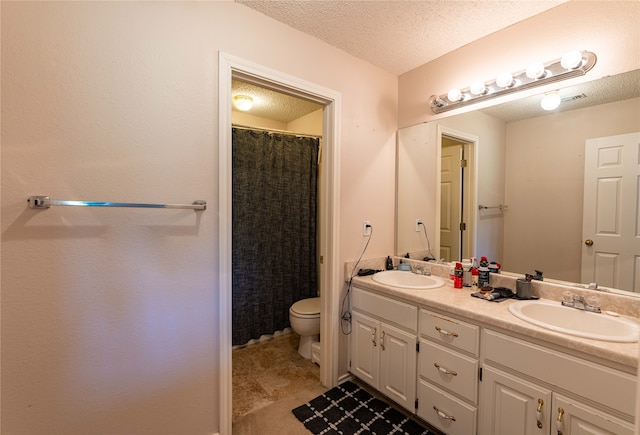 bathroom with vanity, toilet, and a textured ceiling