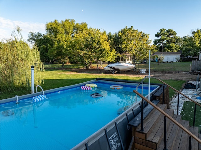 view of pool with a lawn