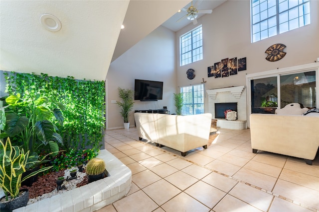 living room featuring a textured ceiling, light tile patterned floors, a towering ceiling, and ceiling fan