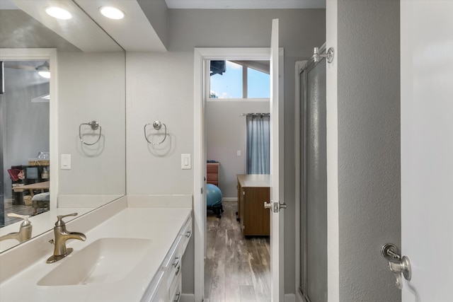 bathroom with wood-type flooring, vanity, and an enclosed shower