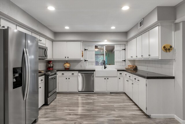 kitchen featuring stainless steel appliances, white cabinets, light hardwood / wood-style floors, and sink