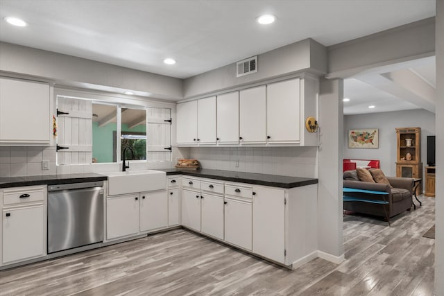 kitchen with sink, tasteful backsplash, light hardwood / wood-style flooring, white cabinetry, and dishwasher