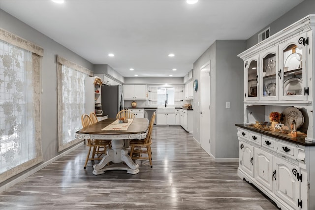 dining space with a healthy amount of sunlight, sink, and dark wood-type flooring