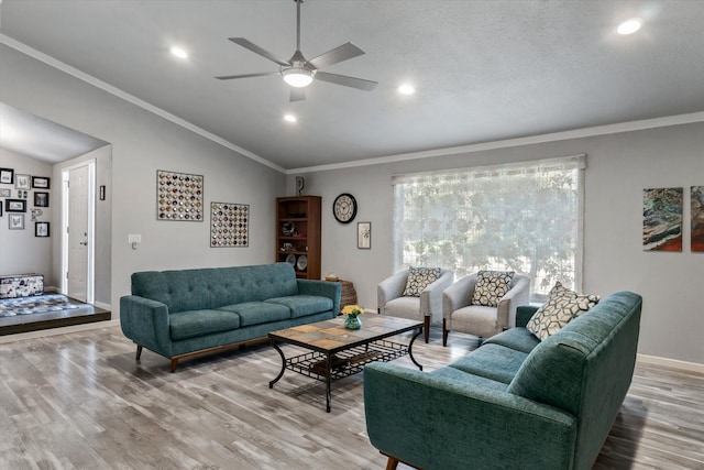 living room featuring ceiling fan, light hardwood / wood-style floors, crown molding, and vaulted ceiling