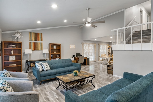 living room with light hardwood / wood-style floors, ornamental molding, and ceiling fan