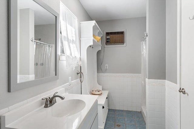 bathroom with tile walls, an AC wall unit, walk in shower, tile patterned floors, and vanity