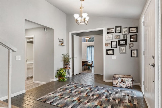 foyer entrance with vaulted ceiling and a notable chandelier