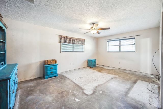 empty room with a textured ceiling, ceiling fan, and concrete floors