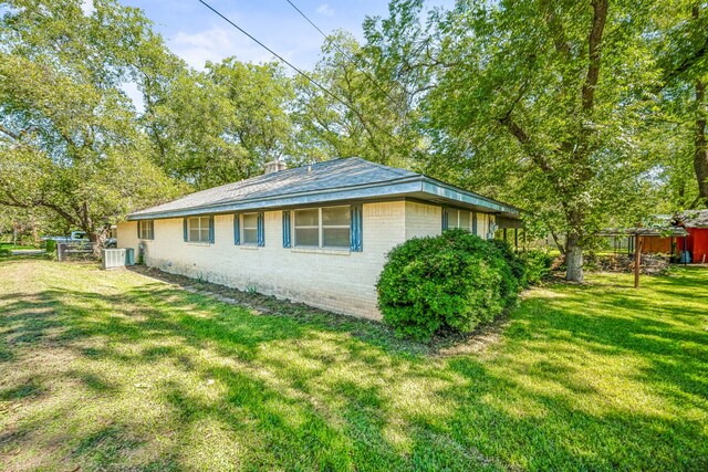 view of side of property with a yard and cooling unit