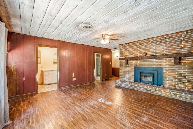 unfurnished living room with brick wall, wood ceiling, ceiling fan, wood-type flooring, and wood walls