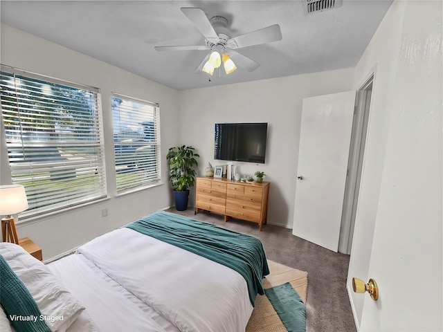 bedroom with ceiling fan and dark carpet