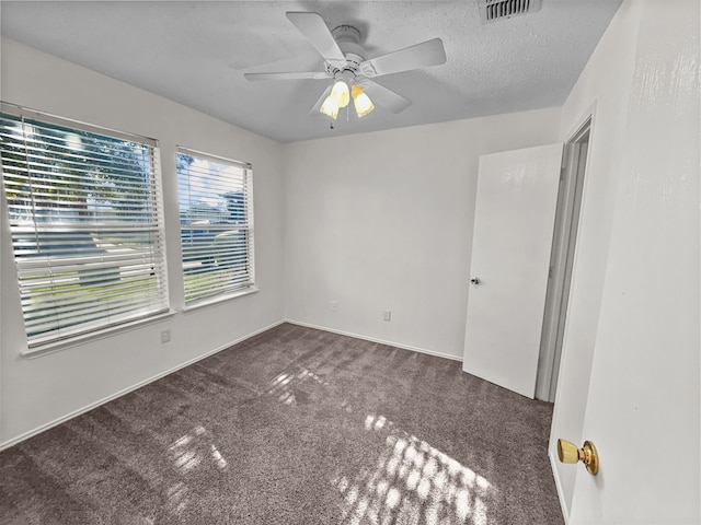 carpeted spare room with ceiling fan and a textured ceiling