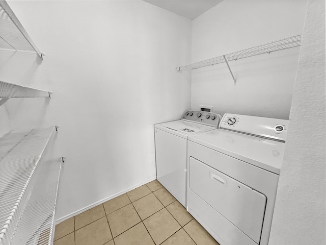 laundry room featuring washer and dryer and light tile patterned floors