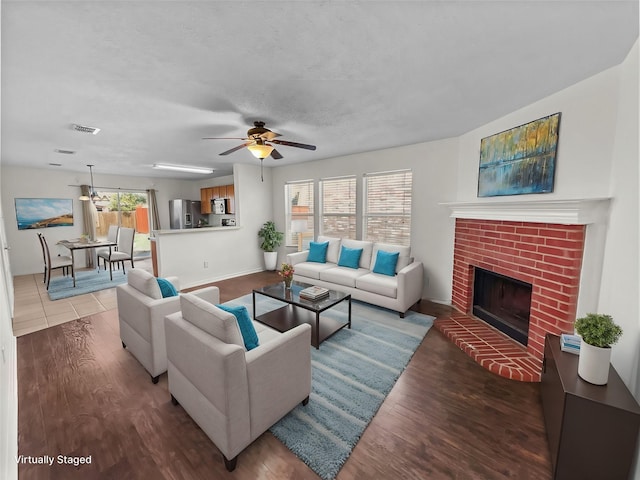 living room with a fireplace, wood-type flooring, plenty of natural light, and ceiling fan