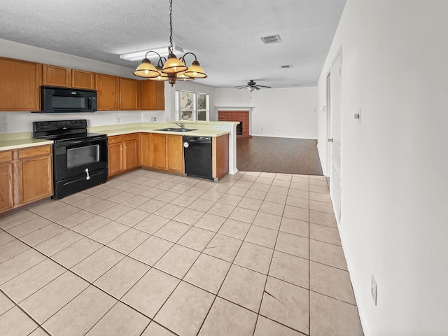 kitchen with ceiling fan with notable chandelier, a textured ceiling, black appliances, pendant lighting, and light tile patterned floors