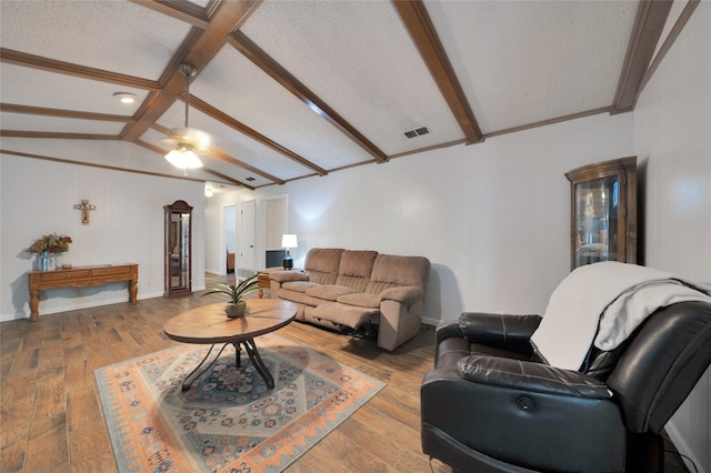 living room featuring hardwood / wood-style flooring, vaulted ceiling with beams, and a textured ceiling