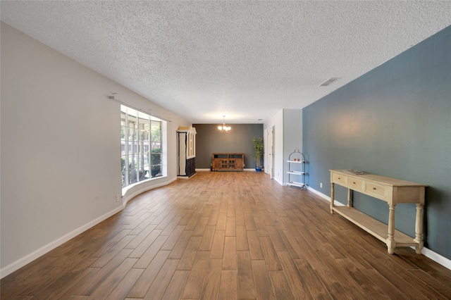 unfurnished living room featuring a textured ceiling and wood-type flooring