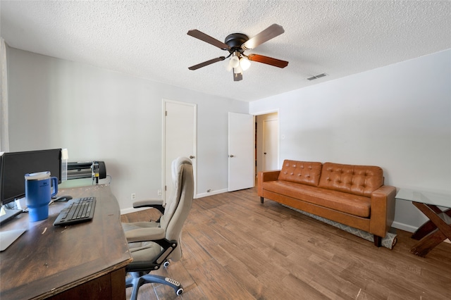 home office featuring ceiling fan, a textured ceiling, and light hardwood / wood-style flooring