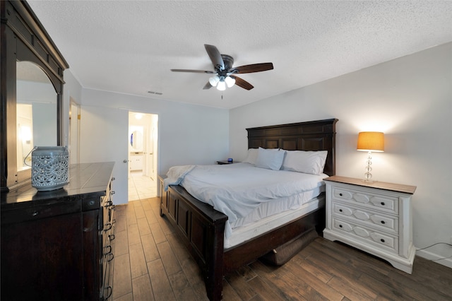 bedroom featuring dark wood-type flooring, a textured ceiling, ceiling fan, and ensuite bath