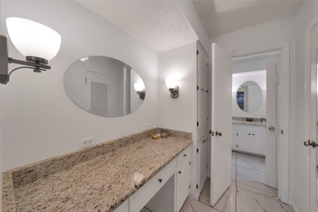 bathroom with vanity and a textured ceiling