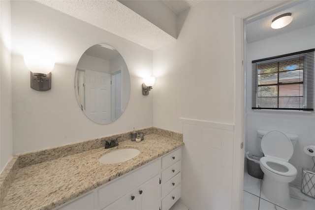 bathroom with vanity, tile walls, and a textured ceiling