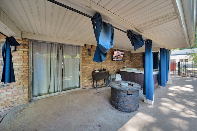 view of patio / terrace with an outdoor fire pit and a hot tub