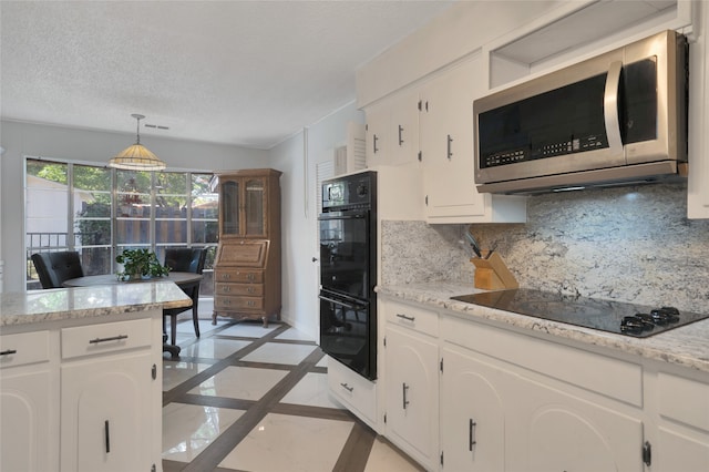 kitchen with hanging light fixtures, decorative backsplash, white cabinets, and black appliances