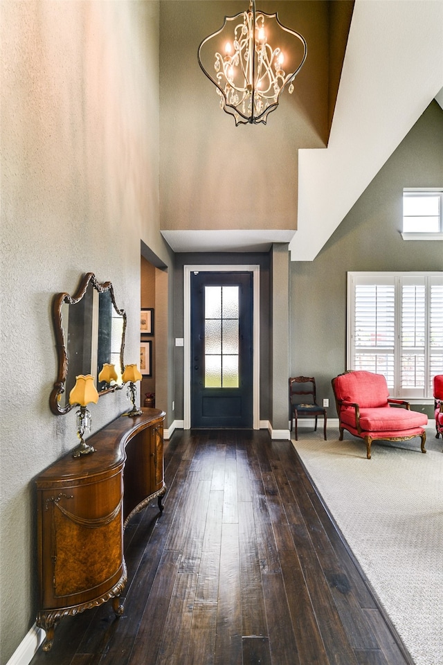 foyer entrance featuring high vaulted ceiling, a healthy amount of sunlight, and dark wood-type flooring