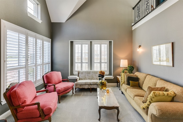 living room with high vaulted ceiling and carpet