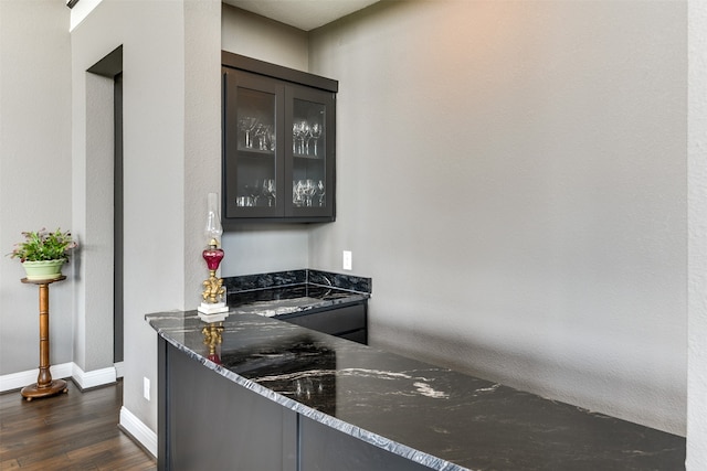 kitchen with dark stone countertops and dark hardwood / wood-style floors