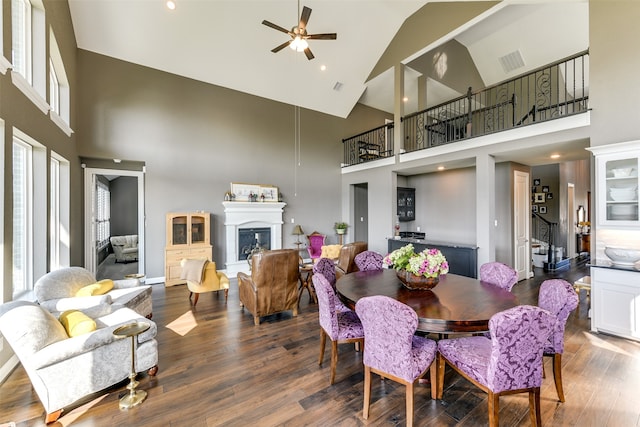 dining area with wood-type flooring, ceiling fan, and high vaulted ceiling