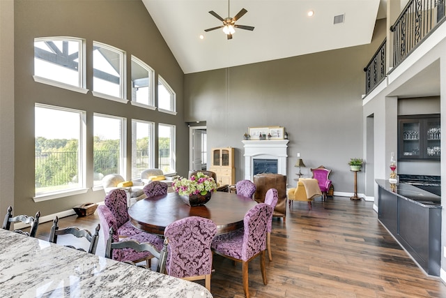 dining space featuring ceiling fan, dark wood-type flooring, and high vaulted ceiling