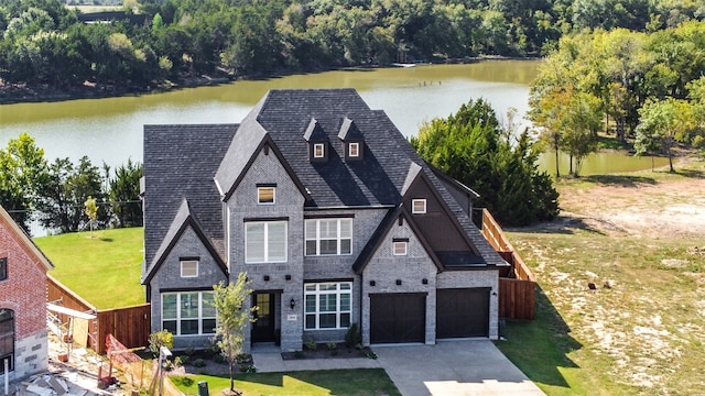 view of front facade with a water view, a garage, and a front yard