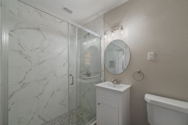 bathroom featuring vanity, an enclosed shower, and toilet