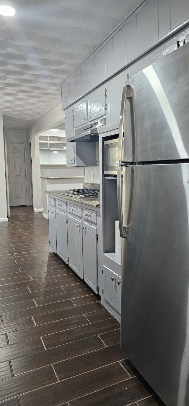 kitchen with stainless steel appliances, white cabinets, dark hardwood / wood-style floors, and tasteful backsplash